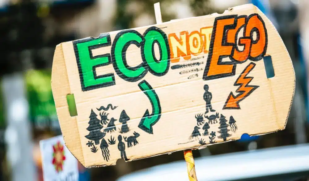 climate change protest sign saying eco not ego