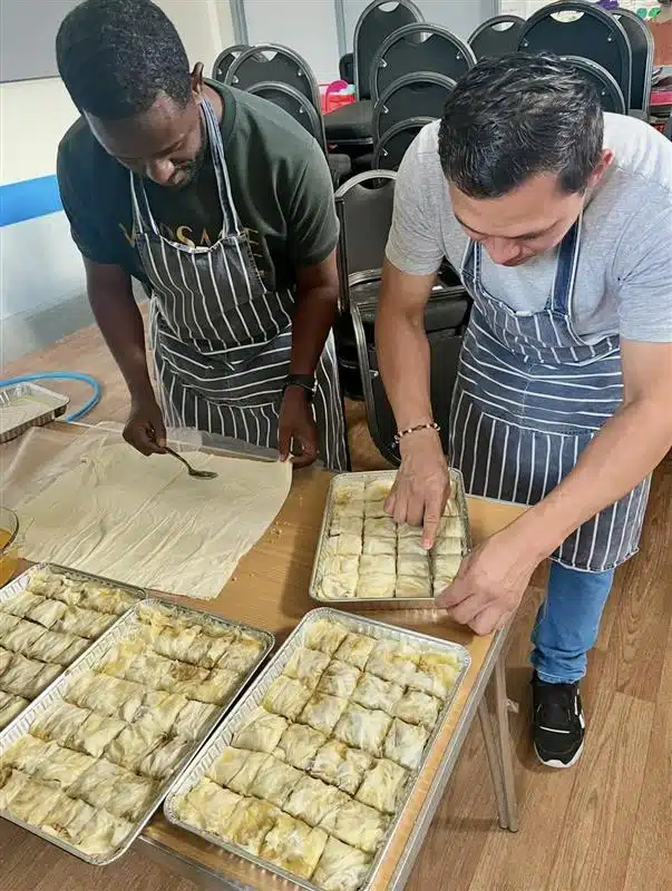 Two men cooking side by side at Napier