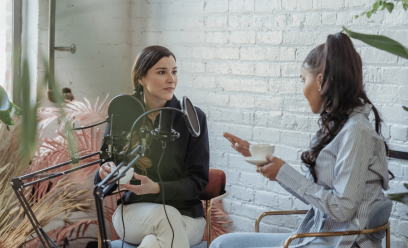 Two women having a discussion in a podcast studio