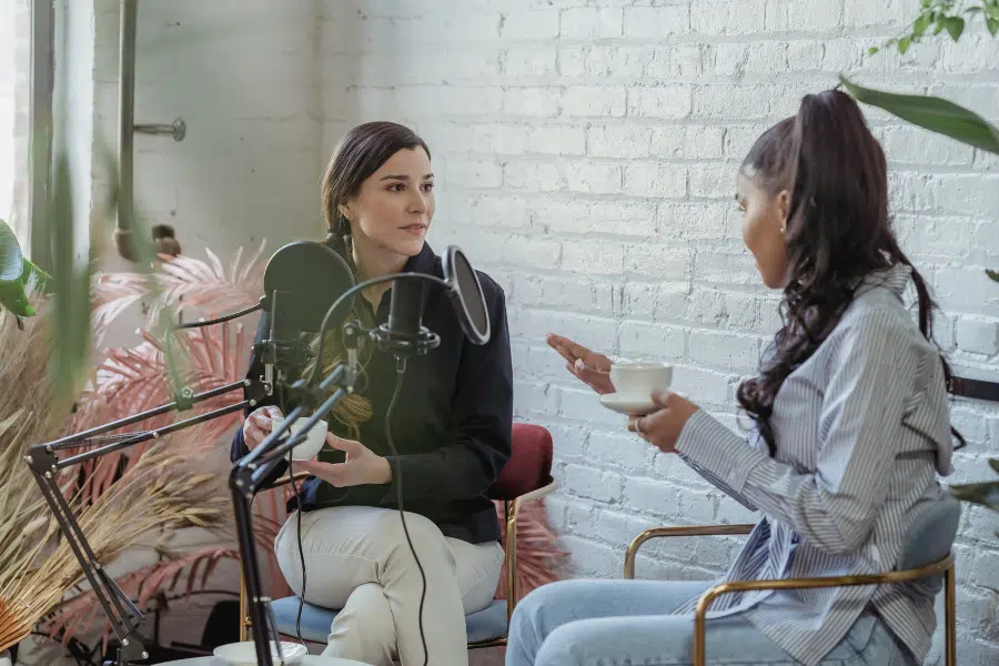 Two women having a discussion in a podcast studio